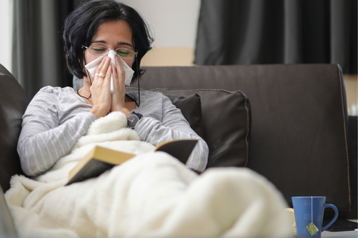 Woman in bed suffering from flue cold. What does the gut and probiotics have to do with colds?