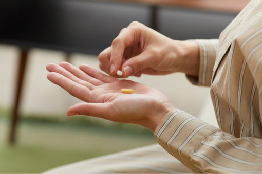 Woman holding a probiotic capsule.