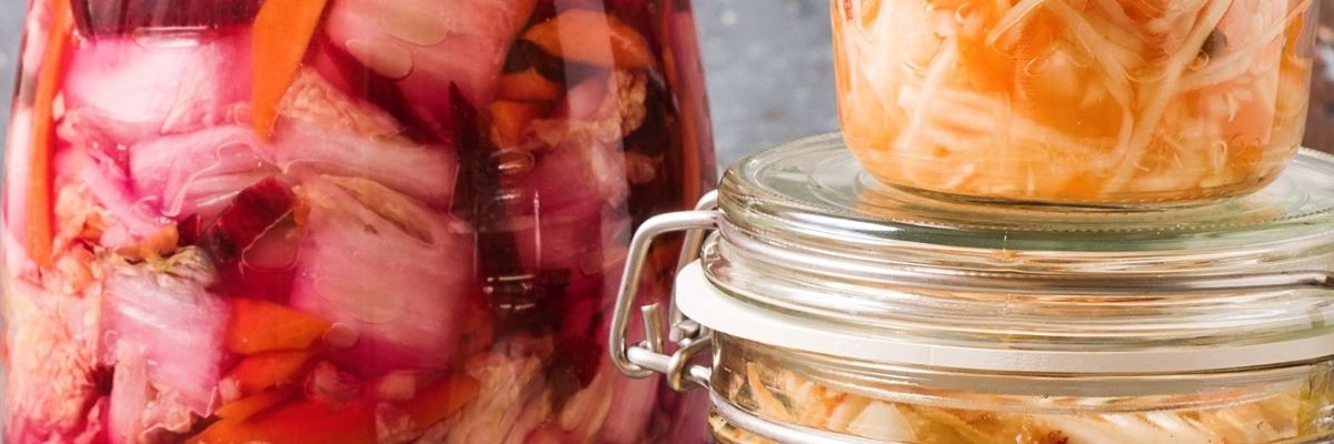 Glass jars filled with colorful fermented vegetables like cabbage and carrots, representing natural sources of probiotics.